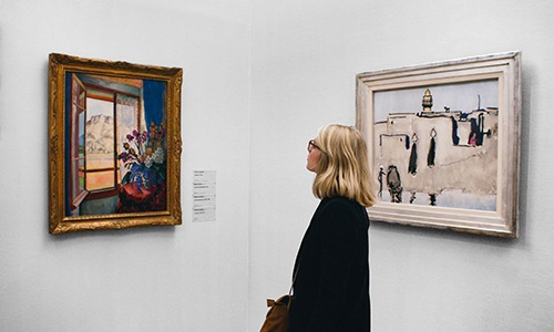 a person looking at art on the wall